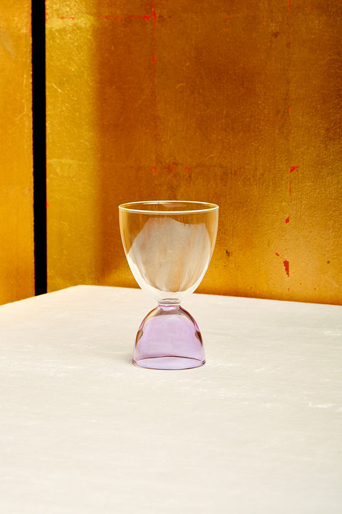 A clear top lavender bottom cocktail glass.
