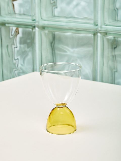 A clear top honey bottom cocktail glass.