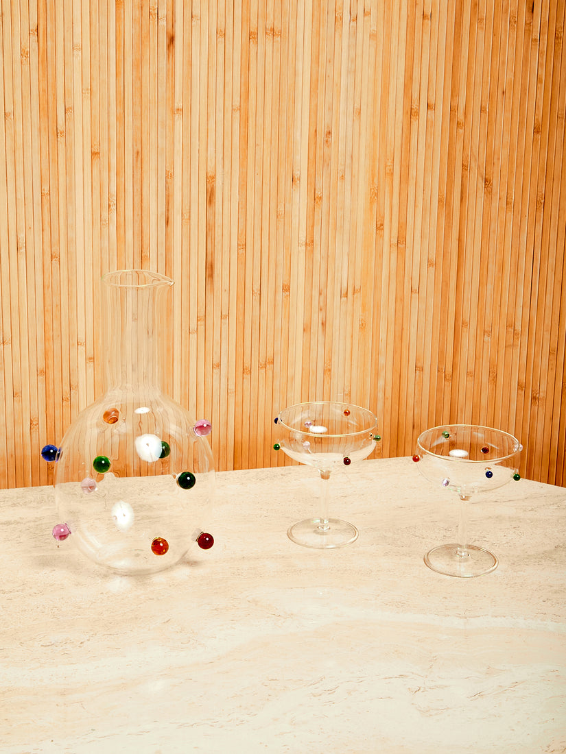 The Dot Carafe by Maison Balzac next to a pair of Multicolor Dot Coupes.