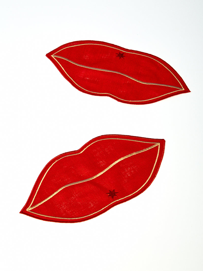 A pair of Bisous Napkins, red with gold graphic lip design and embroidered Maison Balzac logo.