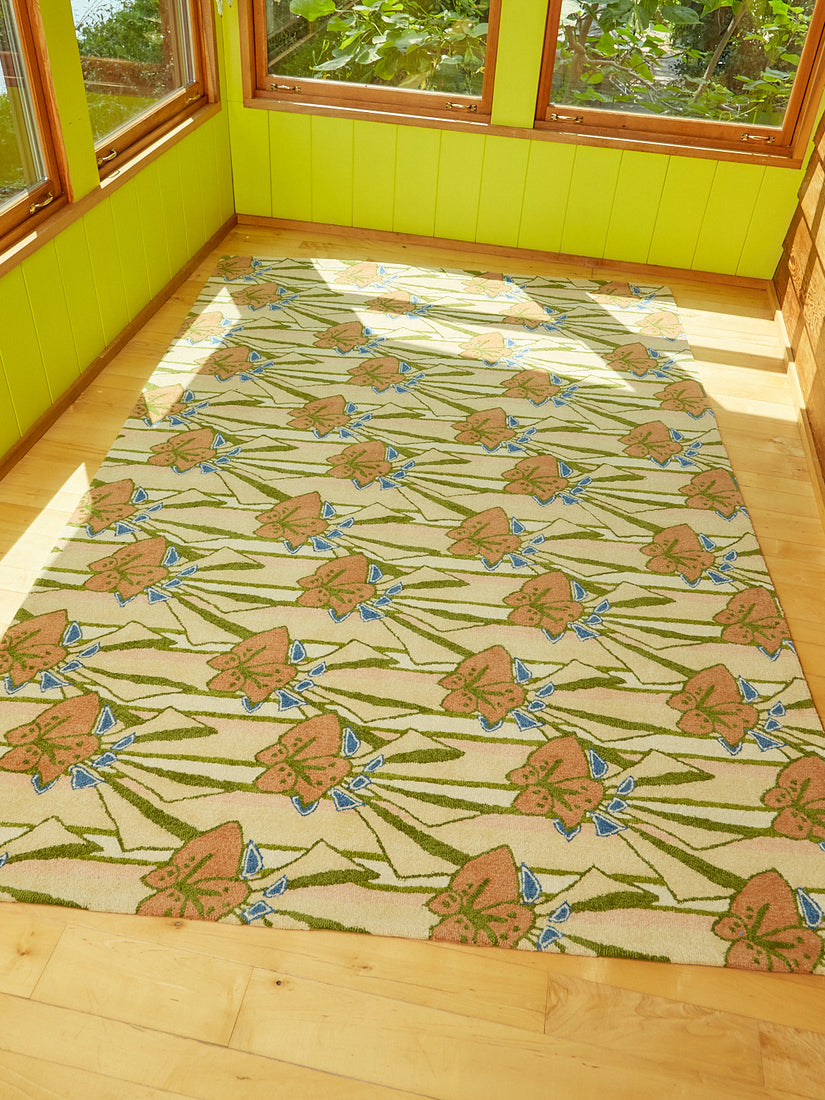 Freckle Flower Rug by Cold Picnic in a bright green sun room with the sun shining on the floor and rug.