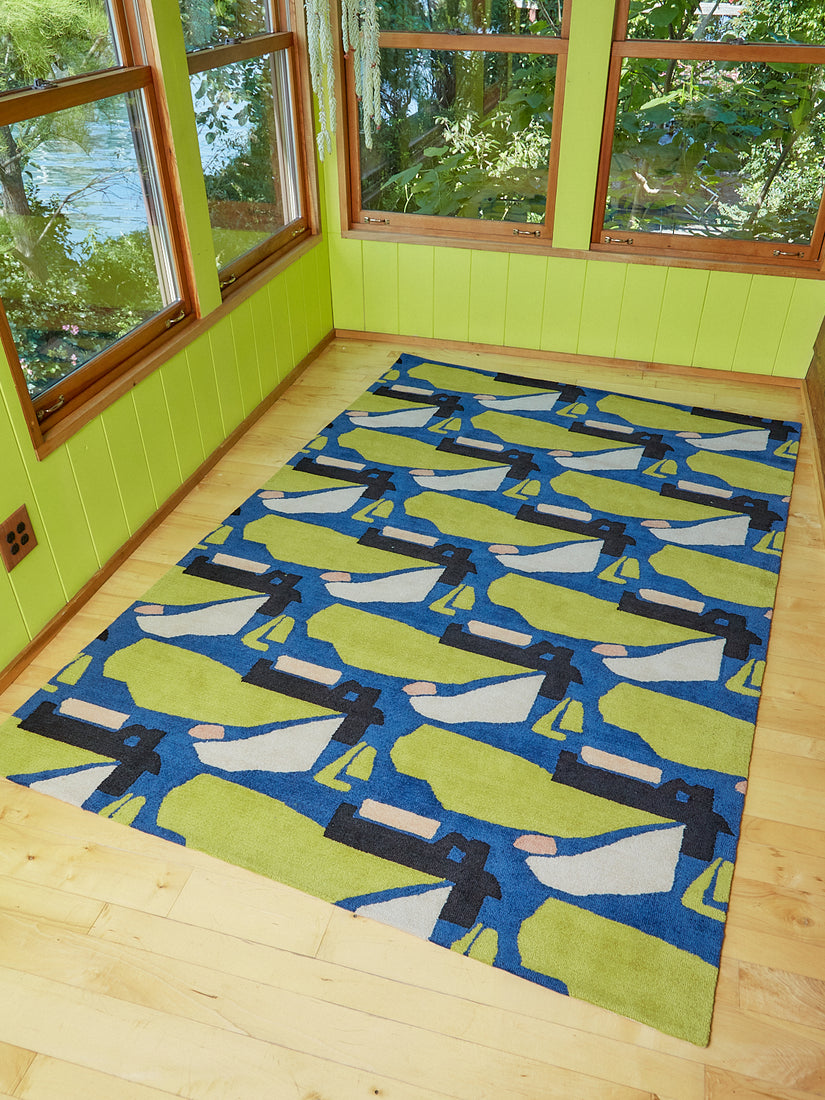 Holy Smoke Rug by Cold Picnic in a bright green sun room covered in windows.