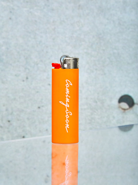 An orange lighter with Coming Soon logo.