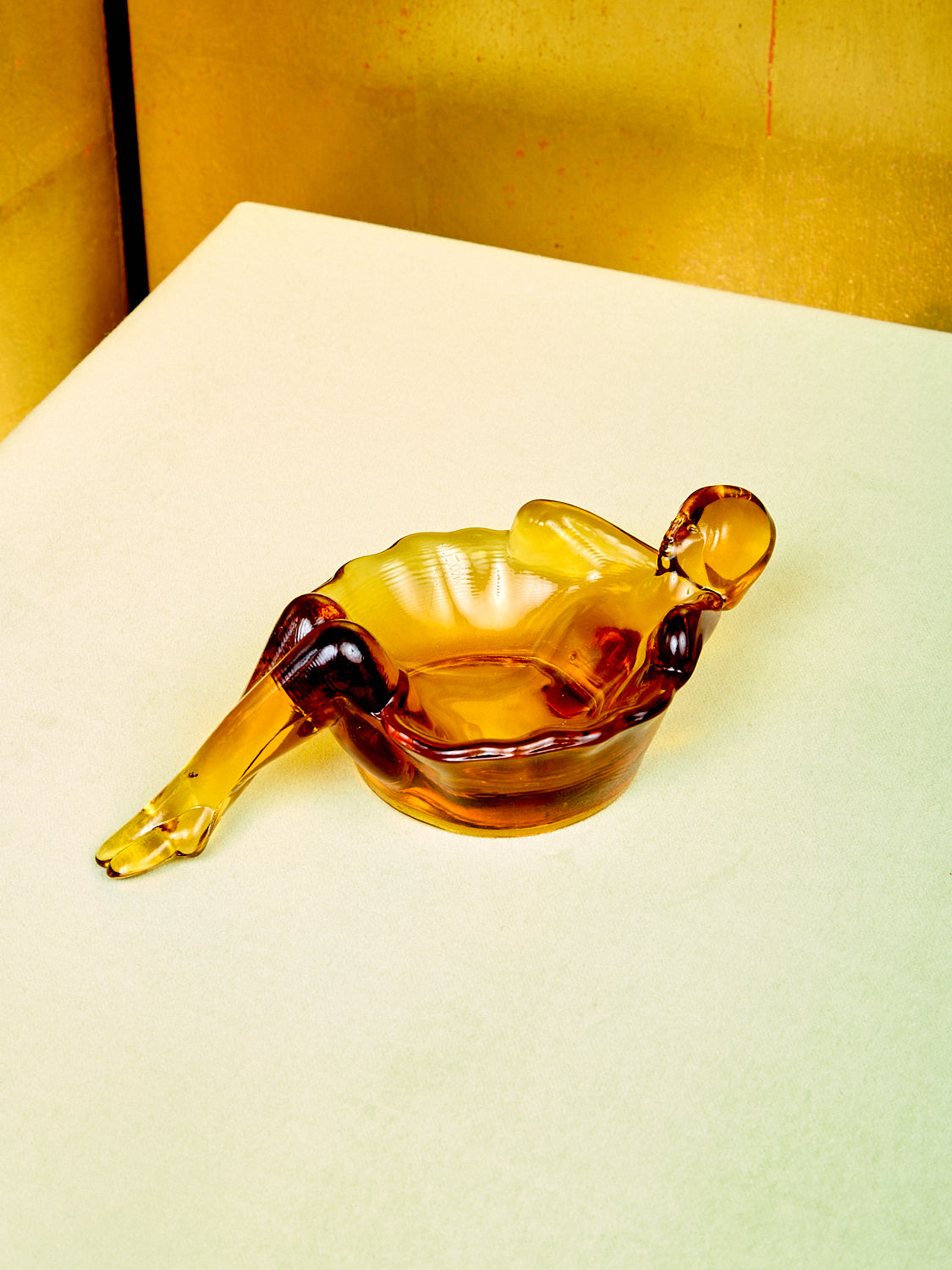 An amber glass bathing lady dish.