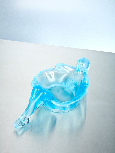 An aqua opal bathing lady on a metallic surface.