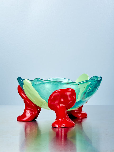 Colorful resin bowl with red feet on a light gray background
