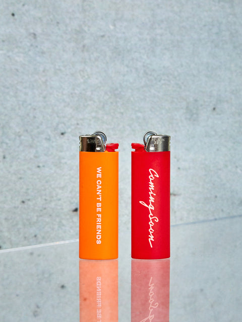 Two Bic Lighters one red and one orange.
