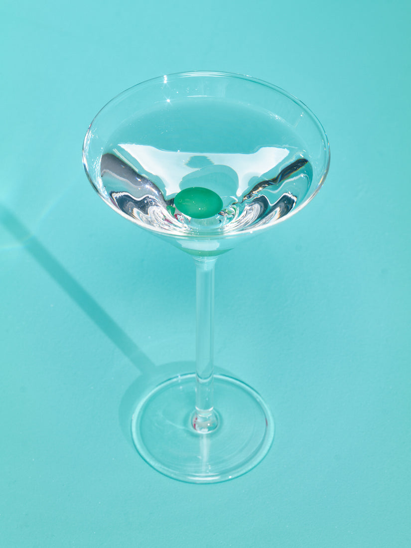 Martini Glass by Maison Balzac full of a clear liquid.