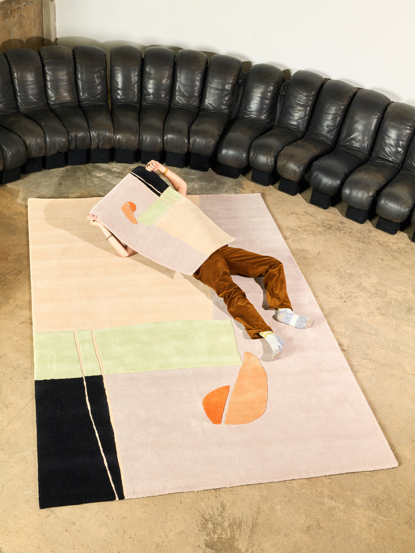 Someone lays across the 6x9 Solaris Rug with a 2x3 over their torso.