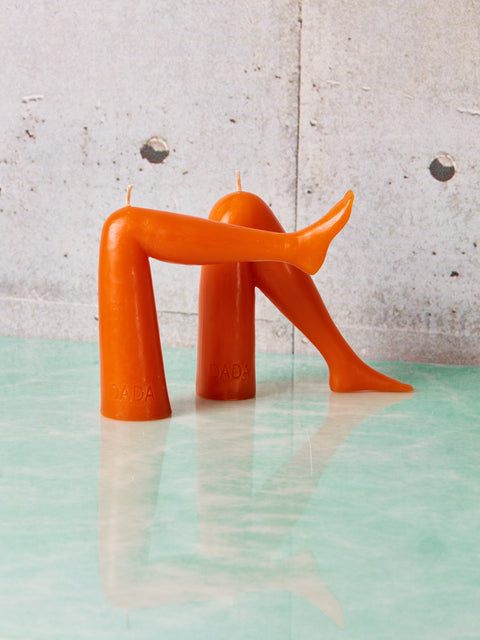A pair of orange leg candles by Dada.