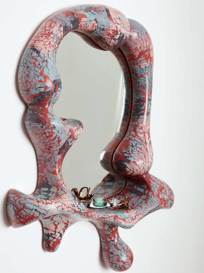 Concrete Cat Iris Mirror in red, blue, charcoal, and pale pink tones.