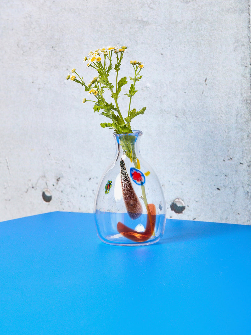 A single Face Carafe Vessel with wildflower stem.