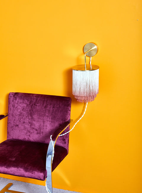 Fringe Wall Sconce by Huldra of Norway mounted to a marigold wall.