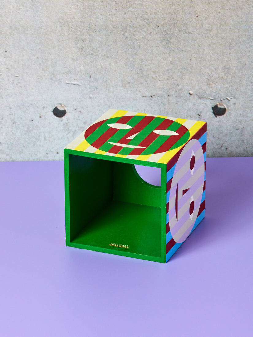 The Tissue Box Holder rests on its side revealing its open end and green interior.