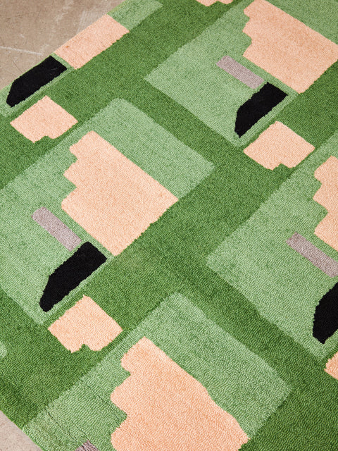Close up of the green and peach pattern of the Purple Noon rug.