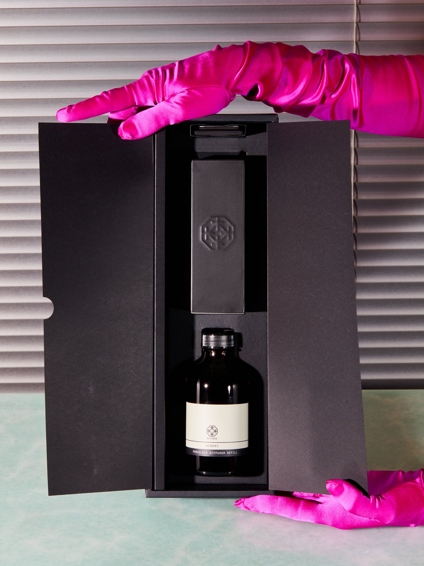 Pink gloved hands present the Porcelain Diffuser kit by Kitowa in its open packaging.