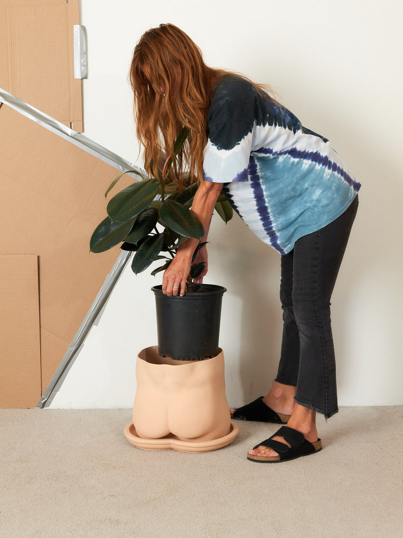 Helena places a rubber tree inside the jumbo nude bottom planter by Group Partner.
