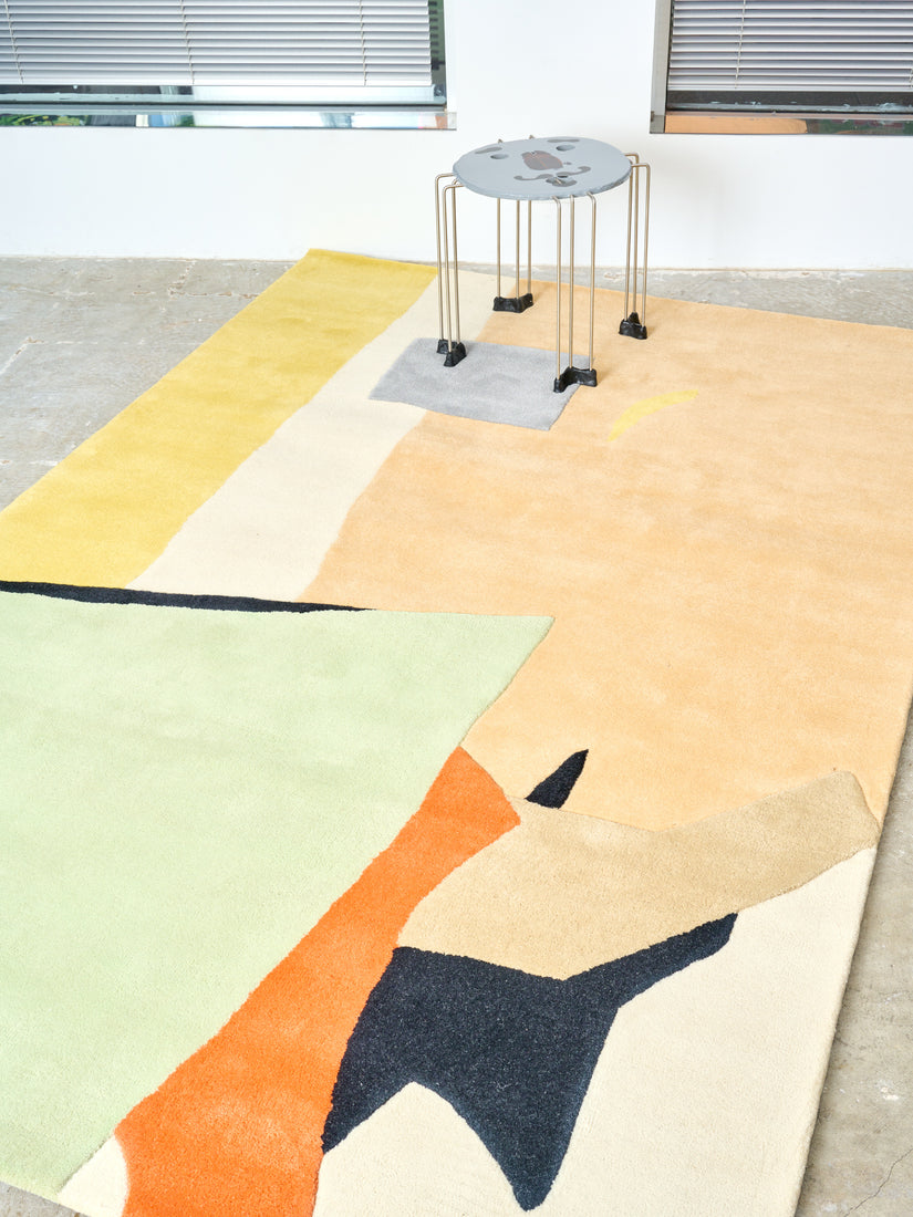 A grey triple play face table sits atop a Beauty is a Dangerous Thing Rug.