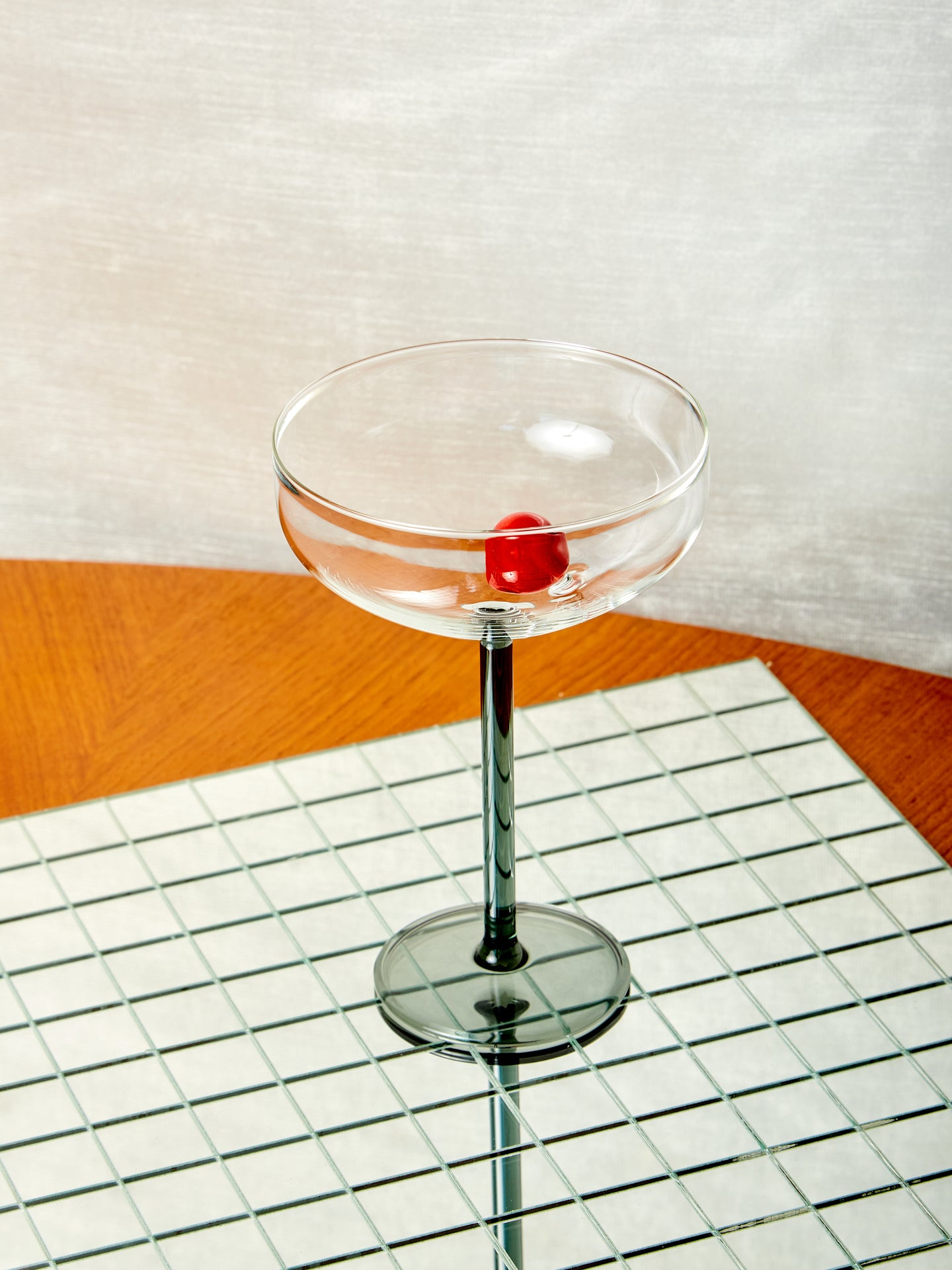 A Manhattan stemmed glass with red glass cherry inside.