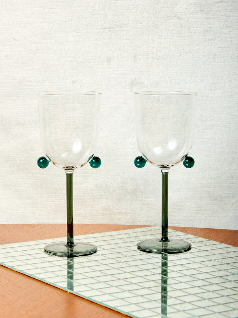 A pair of smoke/teal Pompom Wine Glasses by Maison Balzac.
