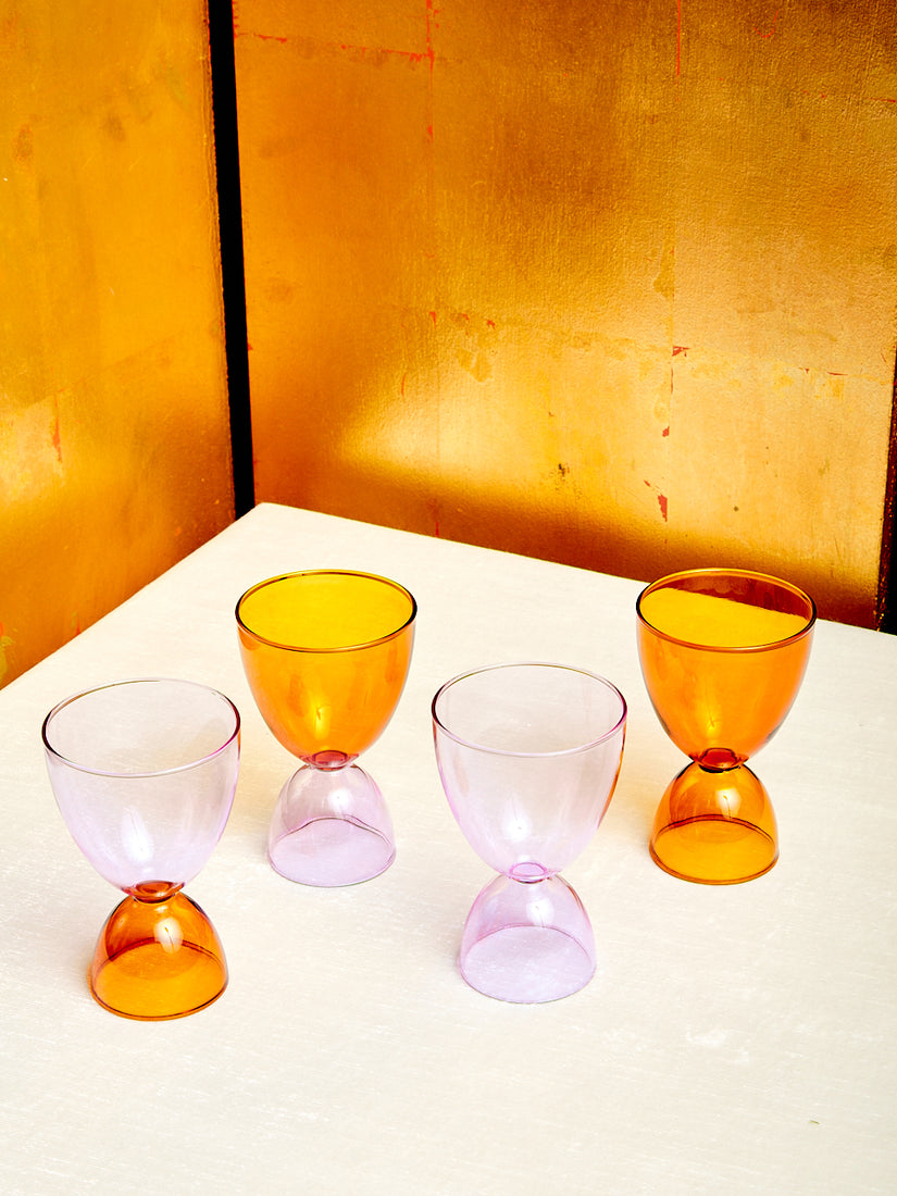Four different lavender and amber cocktail glasses.