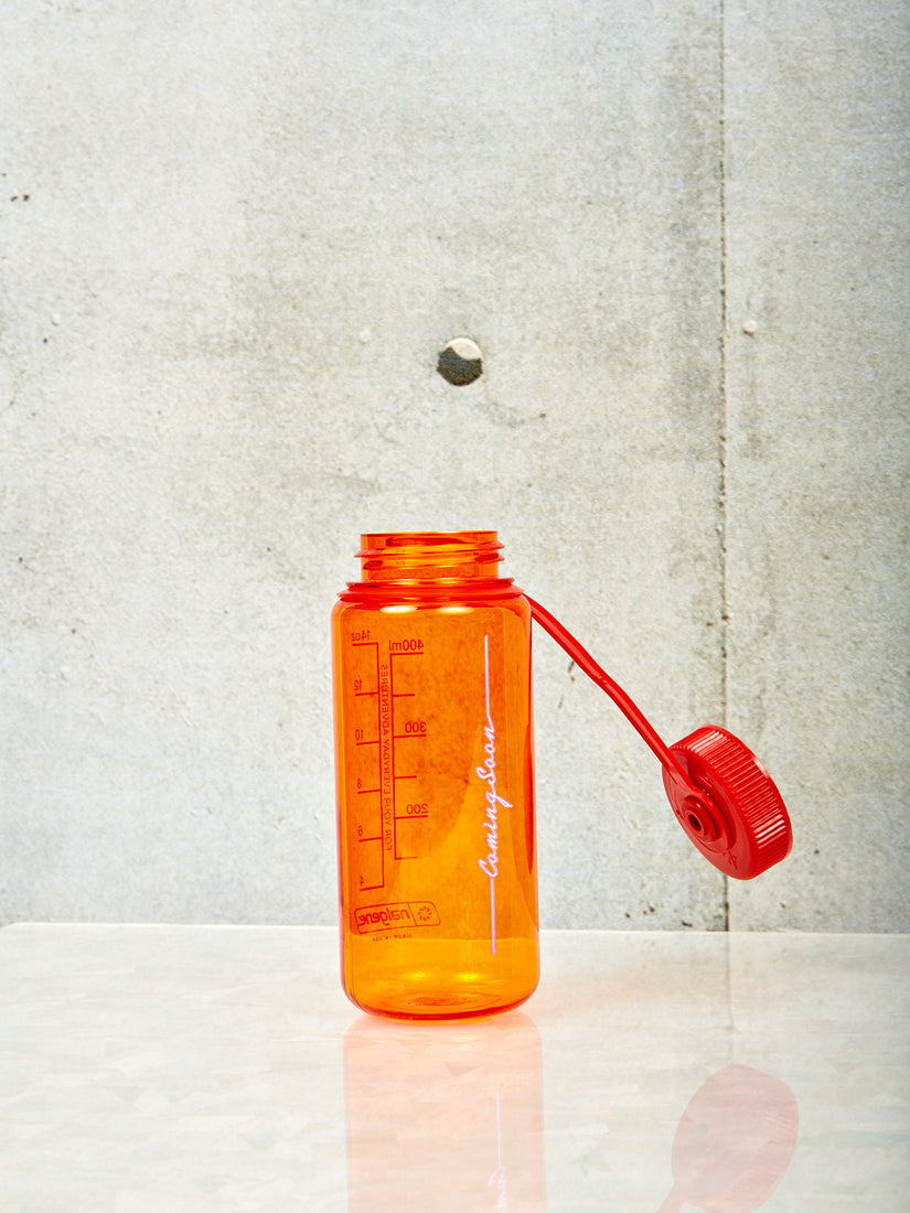 A small orange Nalgene with red lid and pink Coming Soon logo.