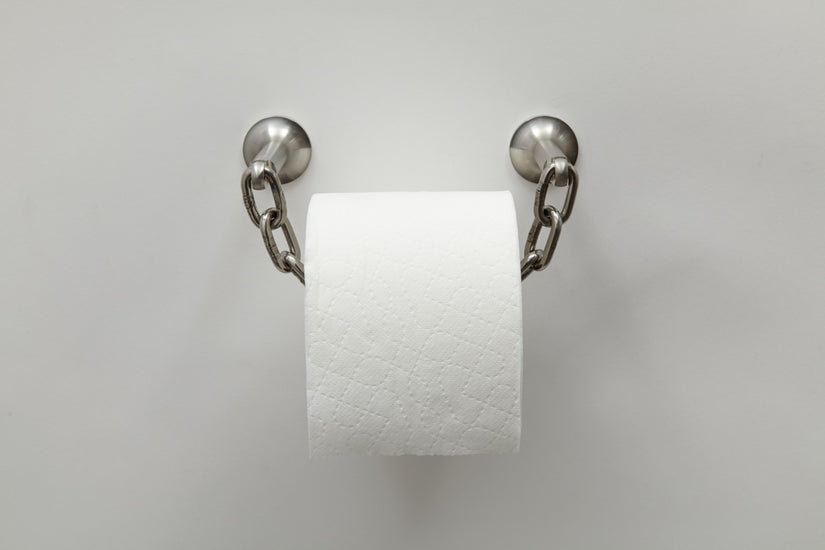 Catena Toilet Paper Holder, a chain loops through the roll of toilet paper and is hung by two stainless steel wall mounts.