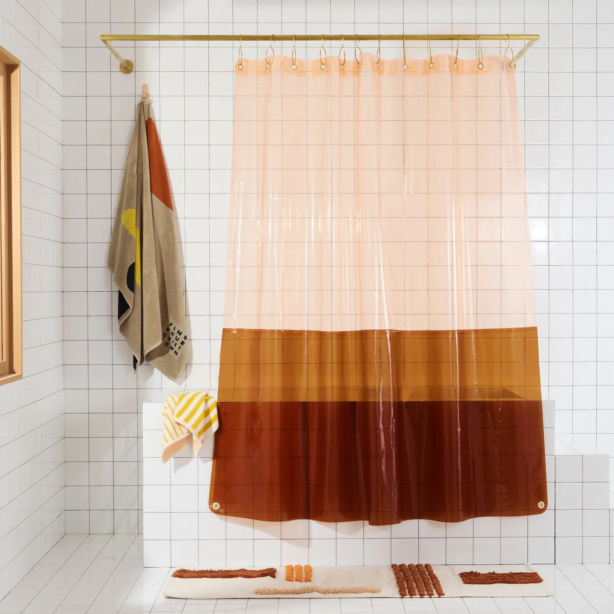 Peach and Amber transparent vinyl shower curtain by Quiet Town hung in a mostly white bathroom.