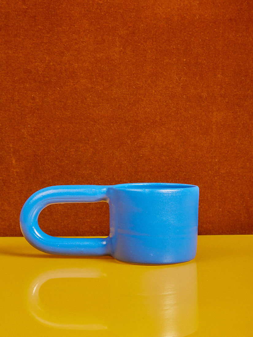 A short mug by Workaday Handmade with an exaggerated handle.