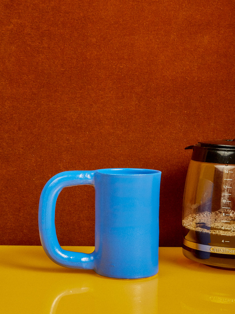 A tall mug by Workaday Handmade in blue galze.
