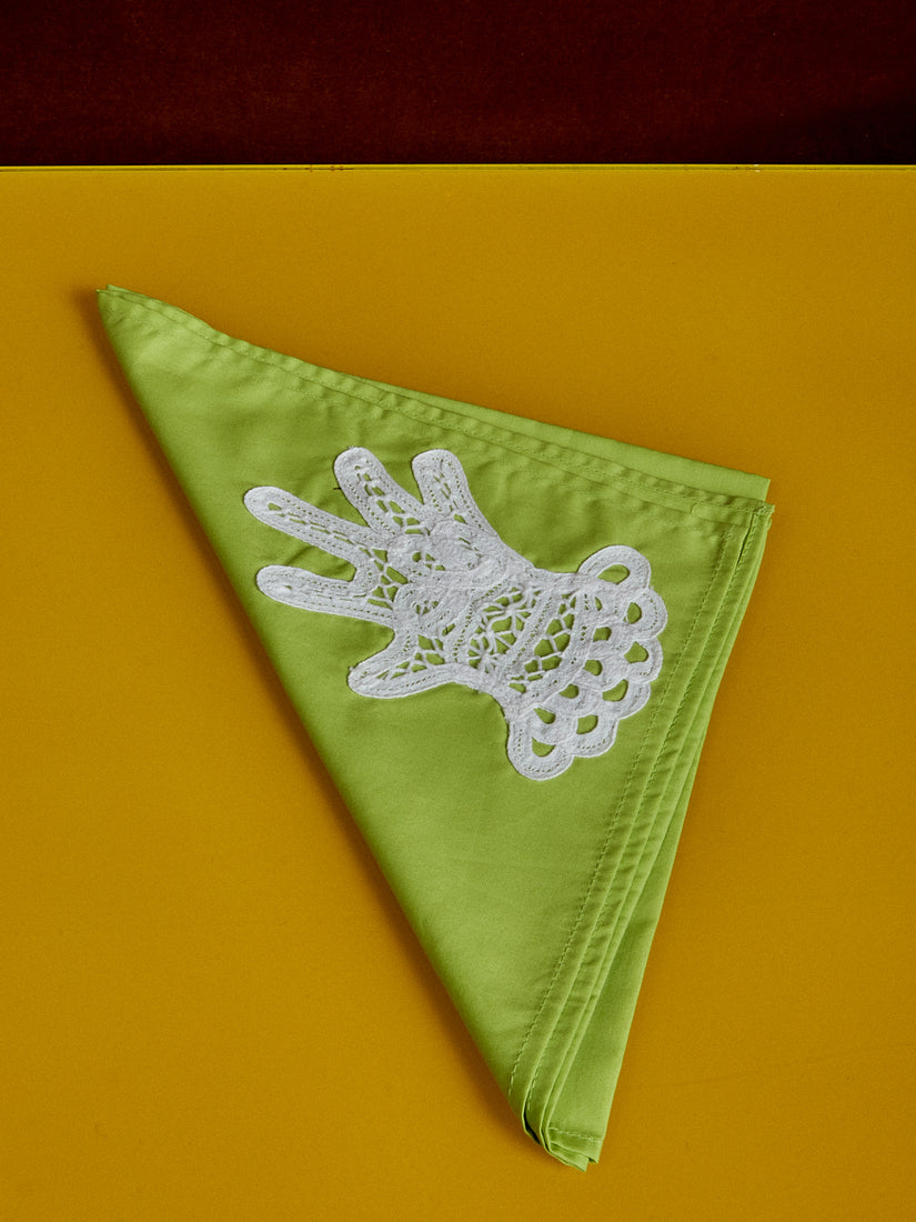 A green dinner napkin with lace appliqué hand by Gohar World.