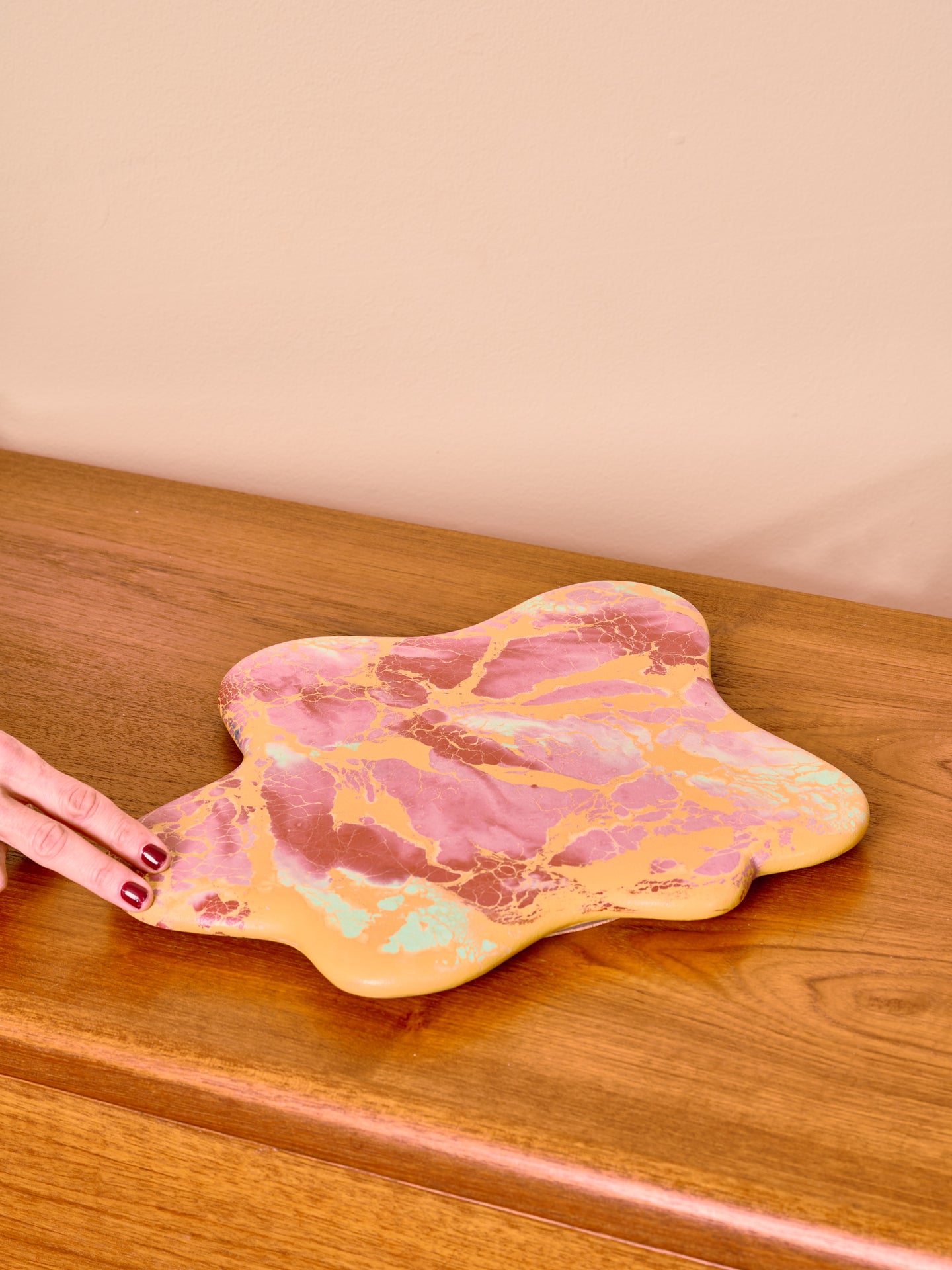 Pink and yellow marbled lazy susan on a wooden surface