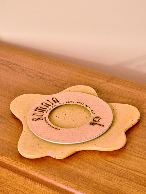 Round beige product with 'Somnia' branding on a wooden surface
