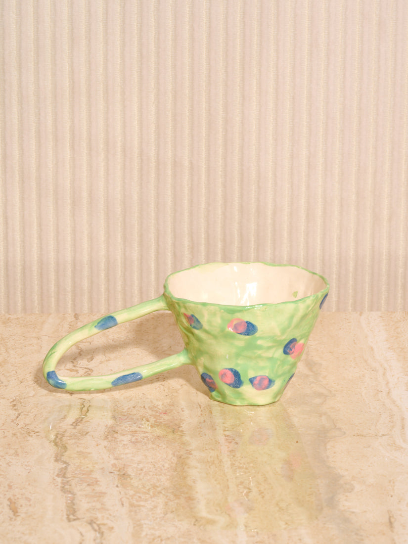 Green Ceramic Mug with Peas by La Romaine Editions. A hand-formed ceramic mug with green exterior that's adorned with green and pink dots.