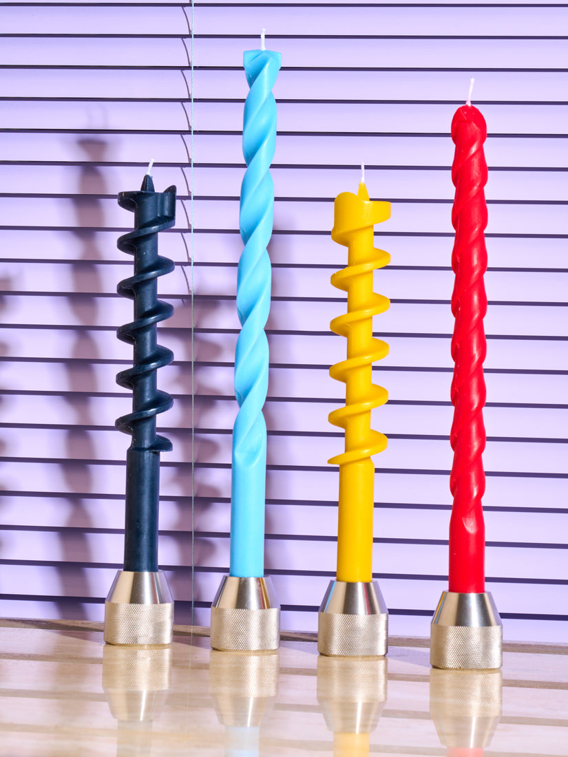 Drill Bit Candles in black, blue, yellow, and red all in the Drill Bit Candle Holder.