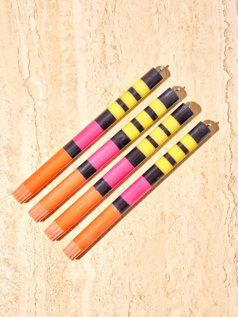 Set of 4 black, yellow, pink, and orange candles by British Colour Standard.