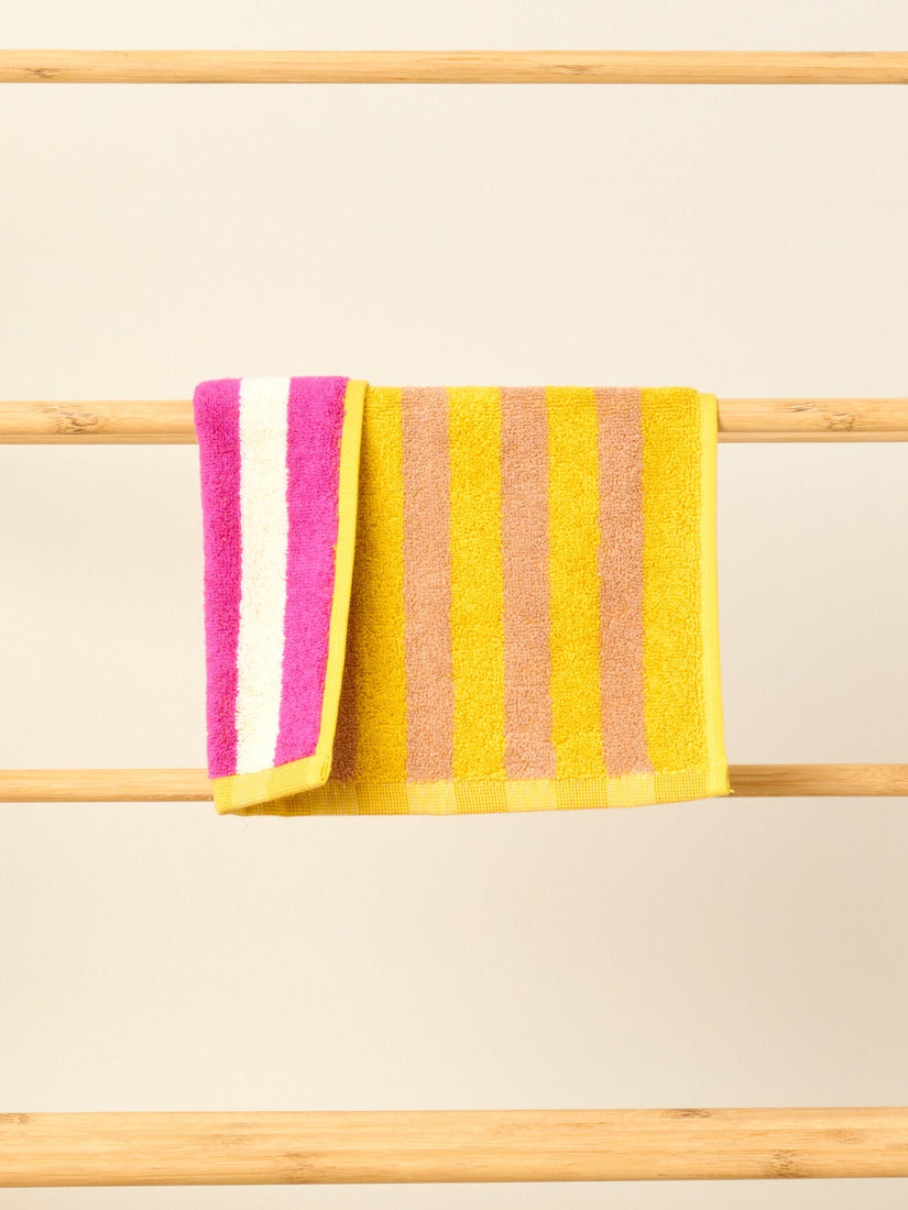 Meadow Washcloth by Dusen Dusen with yellow and brown stripes on one side, purple and white on the other.