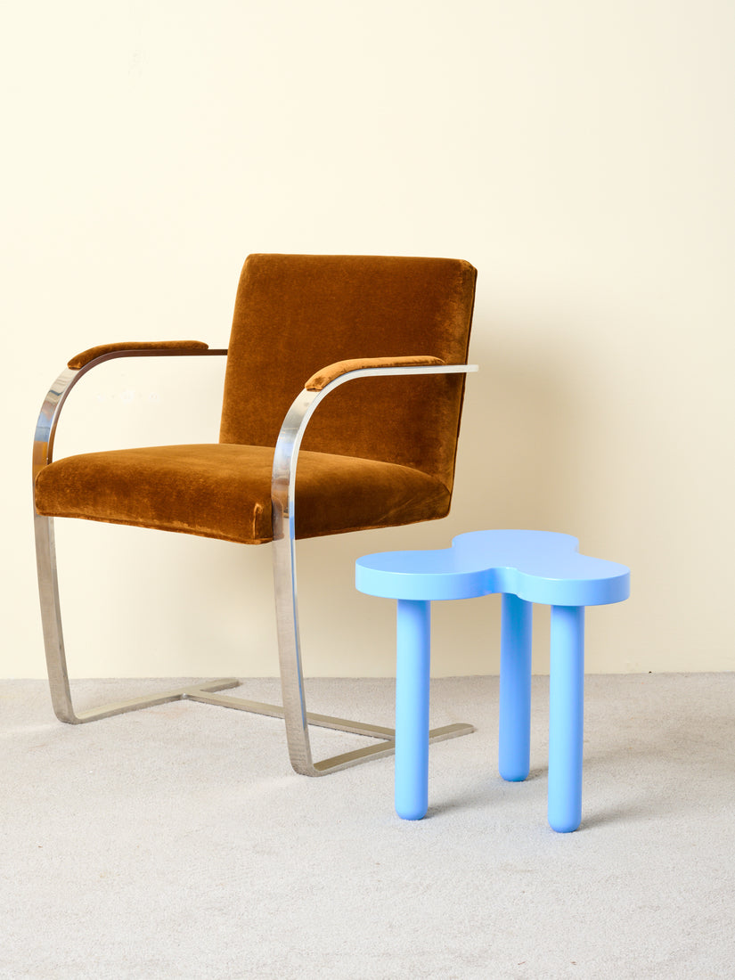 Tall Blue Splat Table sits next to a brown velvet upholstered Brno Flatbar Chair.