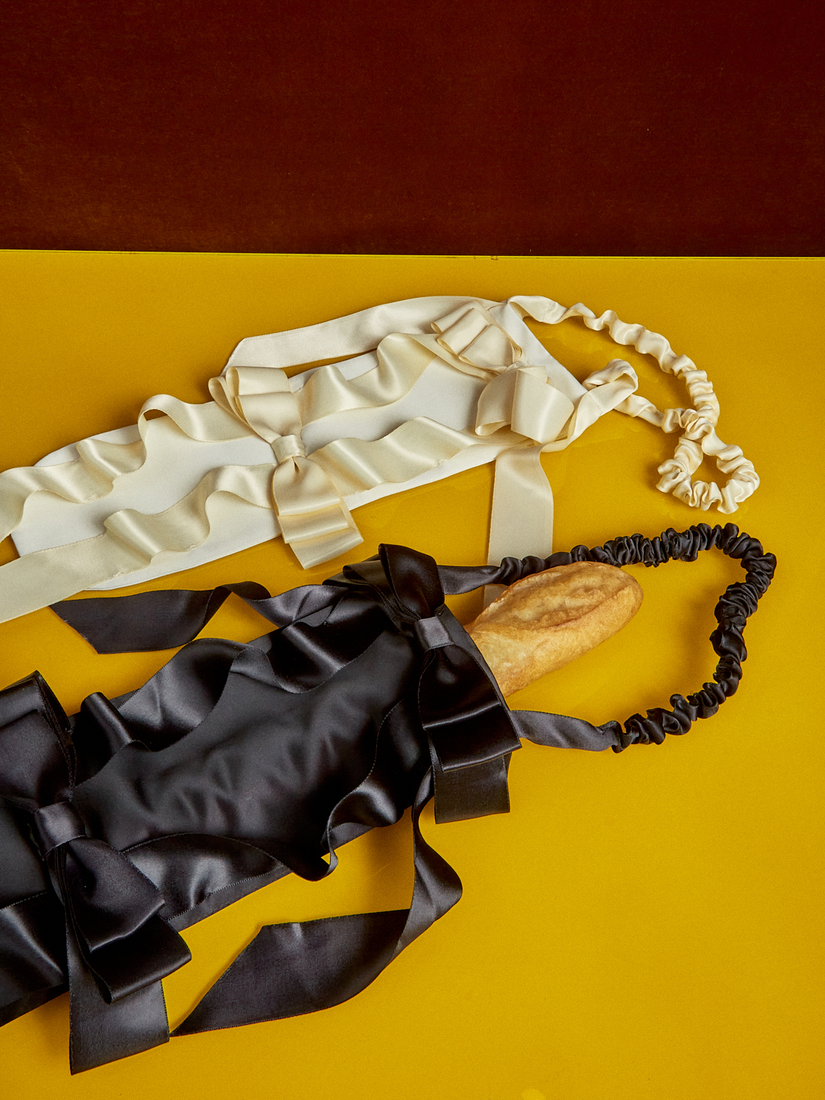 Black and white Baguette Bags by Gohar World. A baguette sits in the black bag.