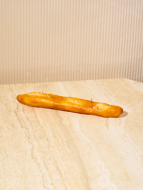 A candle in the shape of a baguette with 2 wicks.