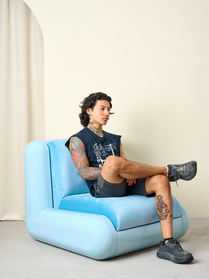 Christiano sits with his legs crossed on a T4 Chair in blue.
