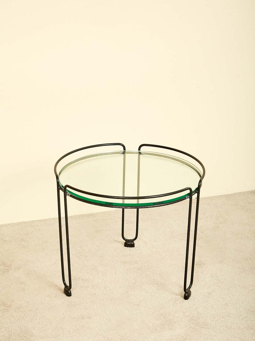 Round side table with continuous iron frame and inset glass top.