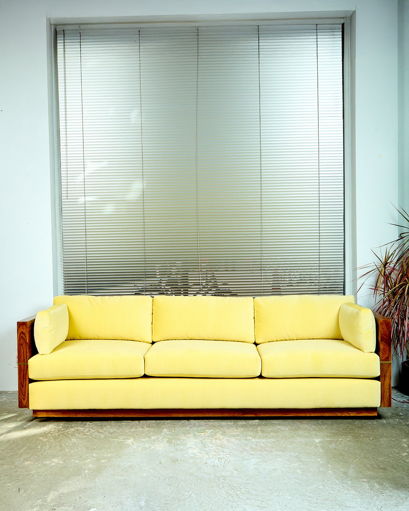 A direct shot of the Milo Baughman Sofa. In this photo you can see the cushions from the front of the couch. Showing its buttery yellow coloring.