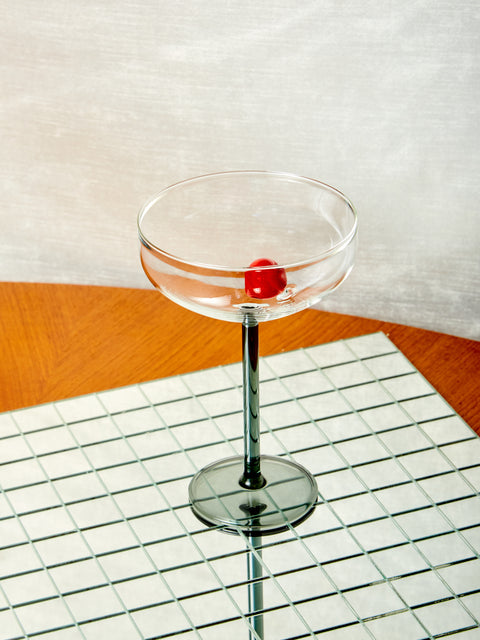 A Manhattan stemmed glass with red glass cherry inside. 