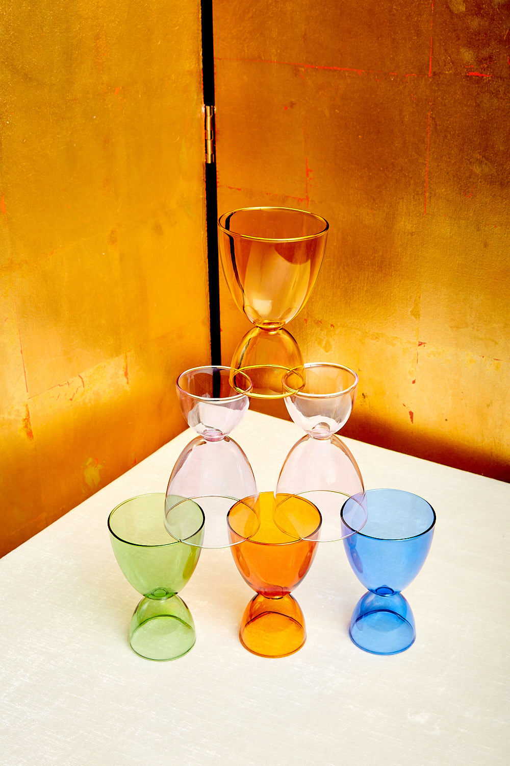 A pyramid of Mamo's cocktail glasses in 6 different monotone colorways.