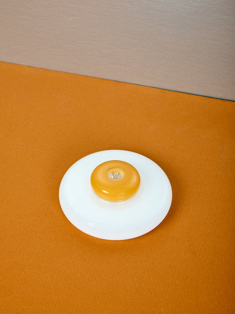 A fried egg shaped incense holder.