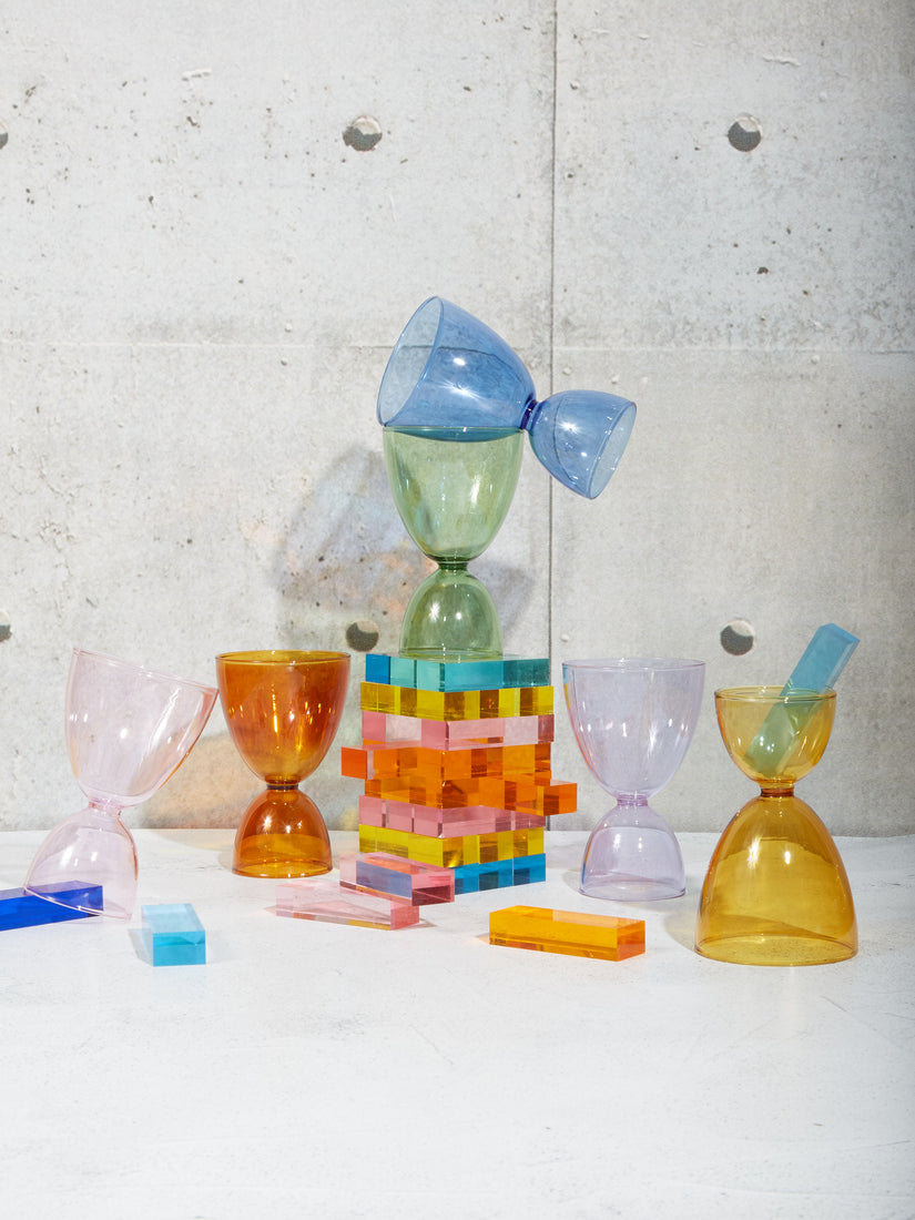 Lucite rainbow stacking game mixed in with a rainbow set of cocktail glasses.