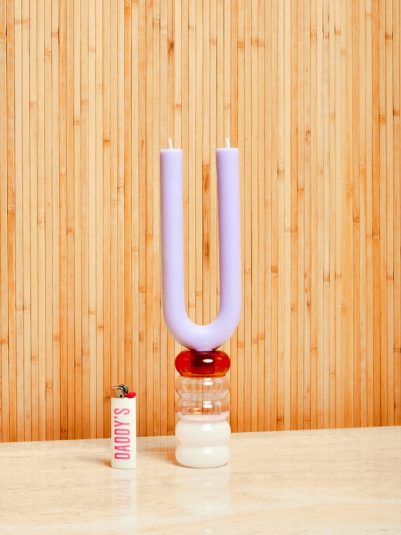 A lighter sits next to a grande Pauline Candle Holder with lavender duet candle inside.