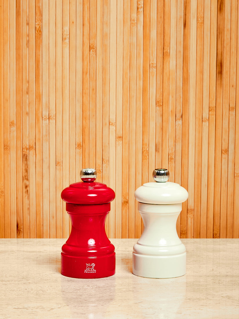 One red and one white Salt and Pepper Mill by Peugeot.