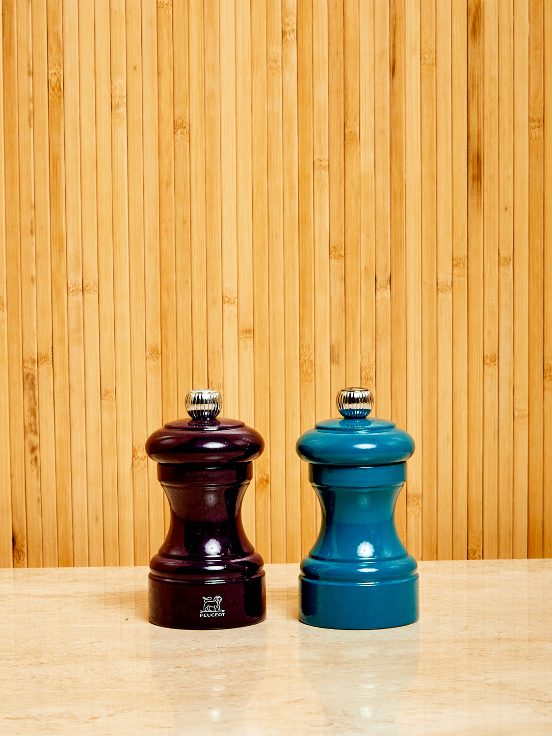 One eggplant and one blue Salt and Pepper Mill by Peugeot.